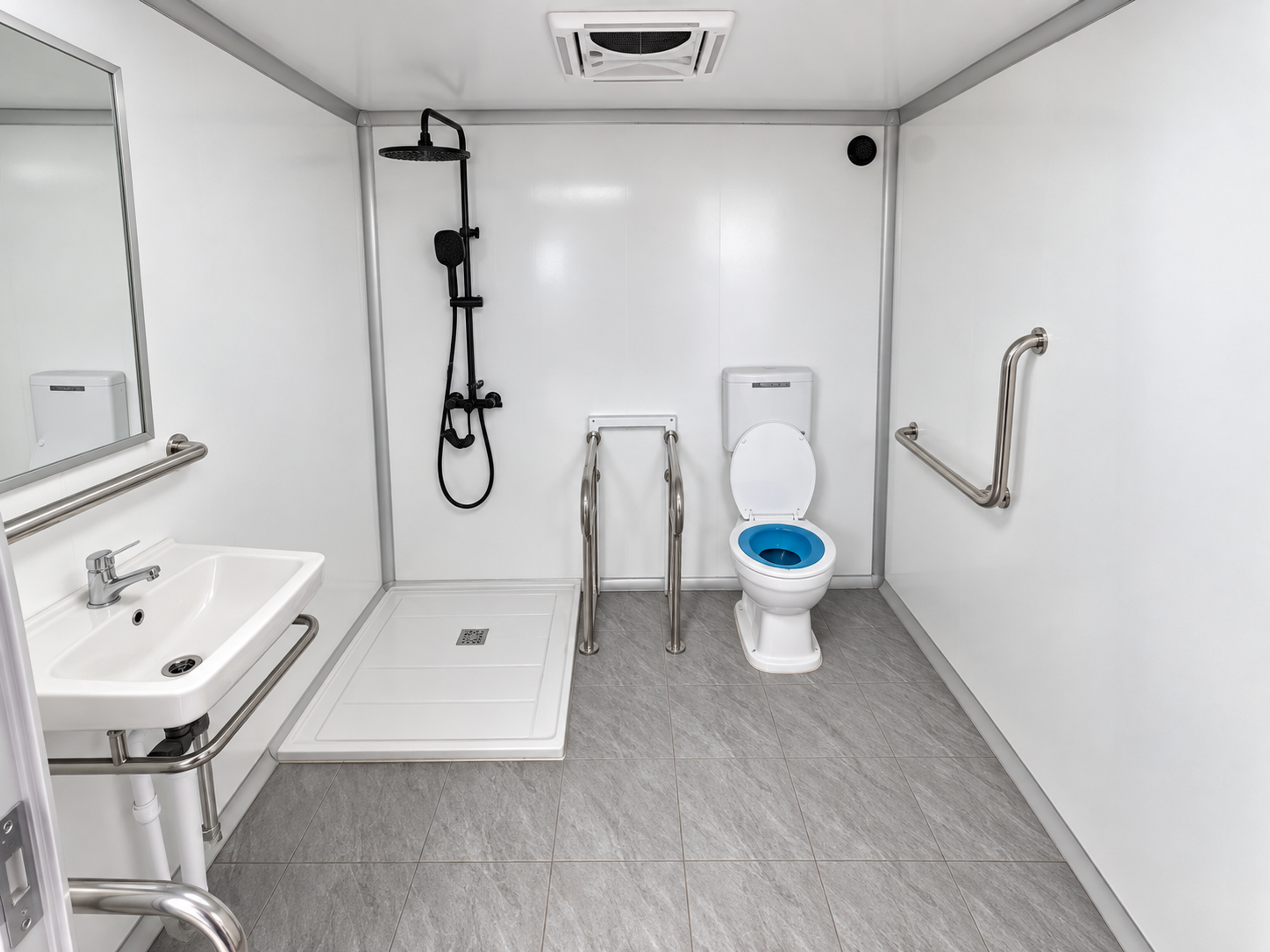 wheelchair accessible stall interior with in-stall shower, grab bars, sink and toilet