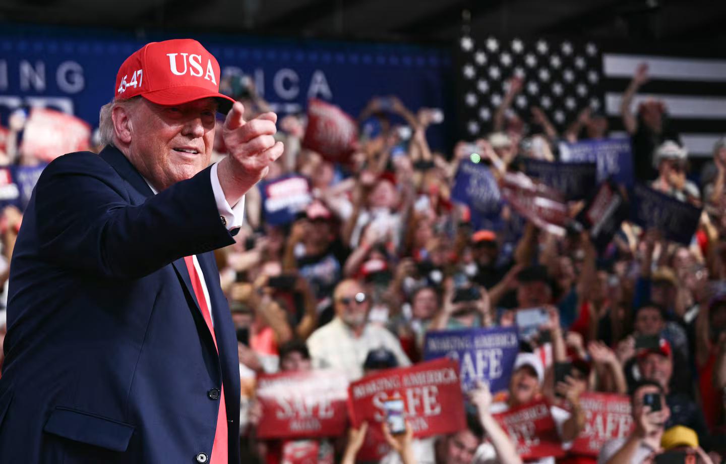 President Donald Trump pointing from a rally stage