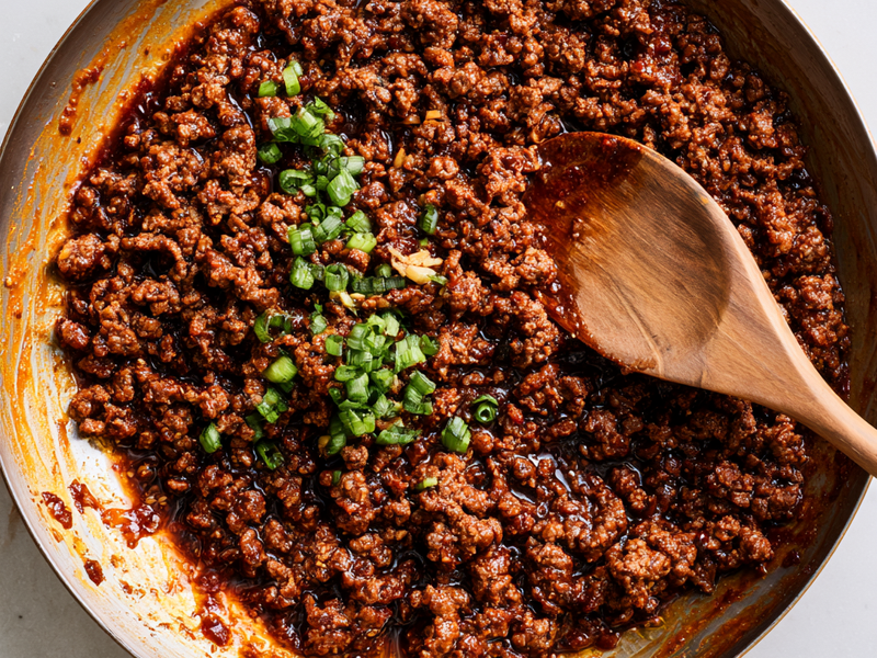Korean gochujang beef simmering in a skillet until the sauce thickens.