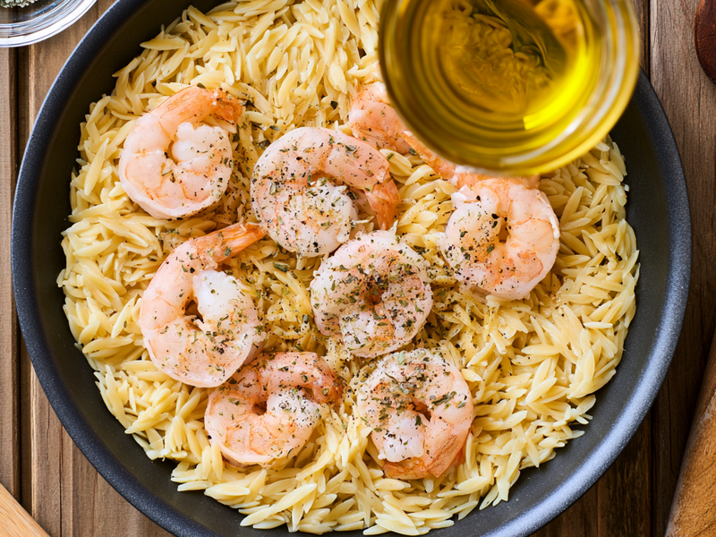 Olive oil heating in a skillet for cooking shrimp.