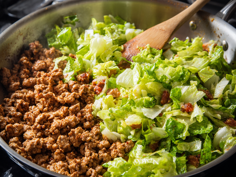 Warm seasoned turkey placed on top of chopped lettuce.
