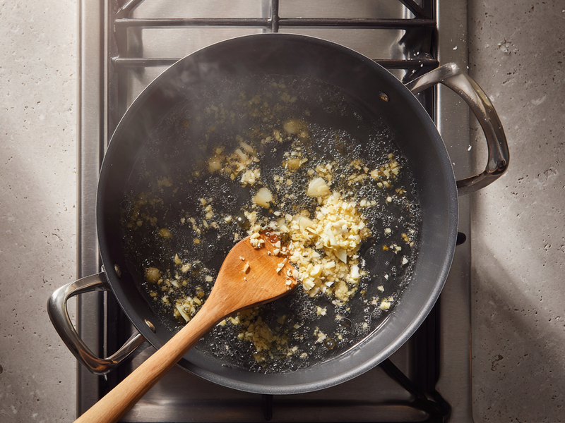 Garlic and ginger sautéing in sesame oil in a pot for gochujang ramen broth