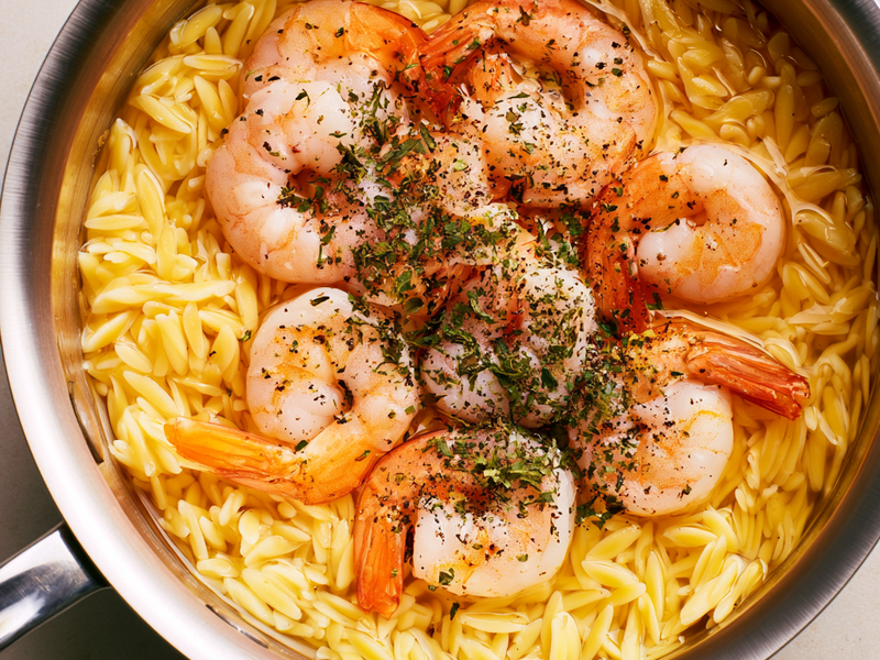Raw shrimp seasoned with oregano, salt, and black pepper before cooking.