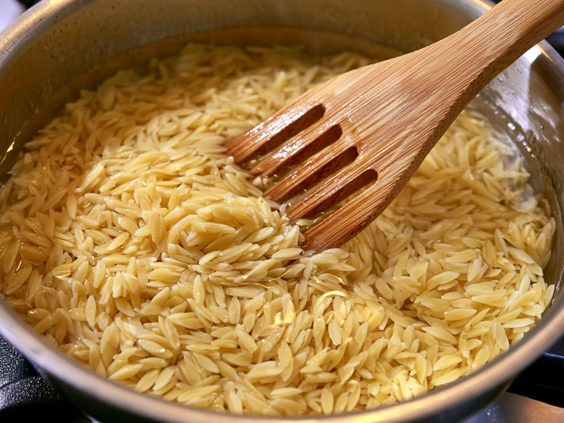 Cooked orzo pasta drained and ready for a Greek shrimp bowl.