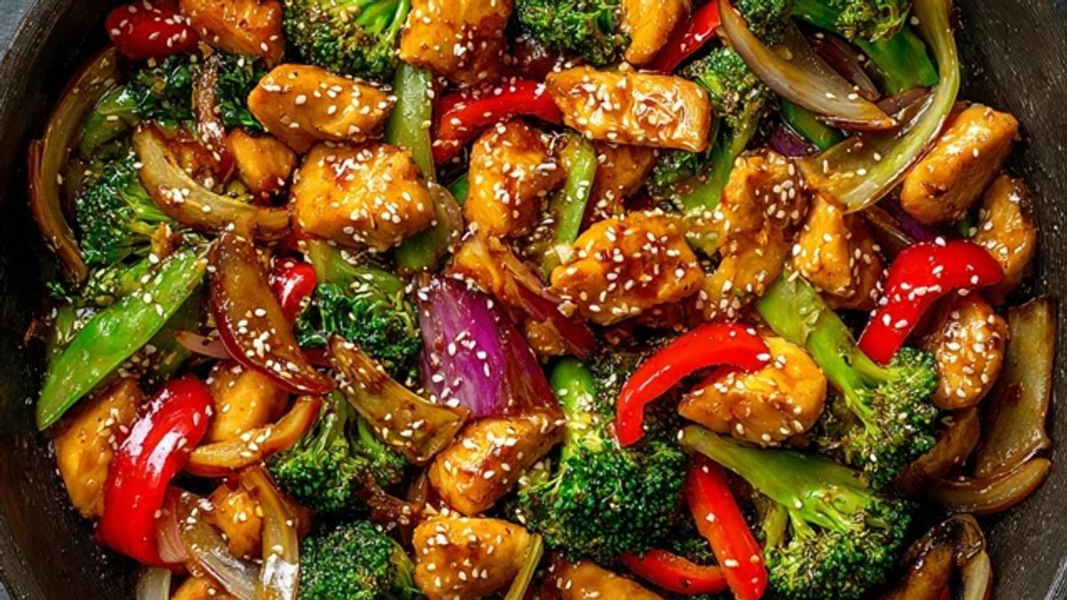 Honey garlic chicken stir-fry with vegetables in a glossy sauce served in a bowl