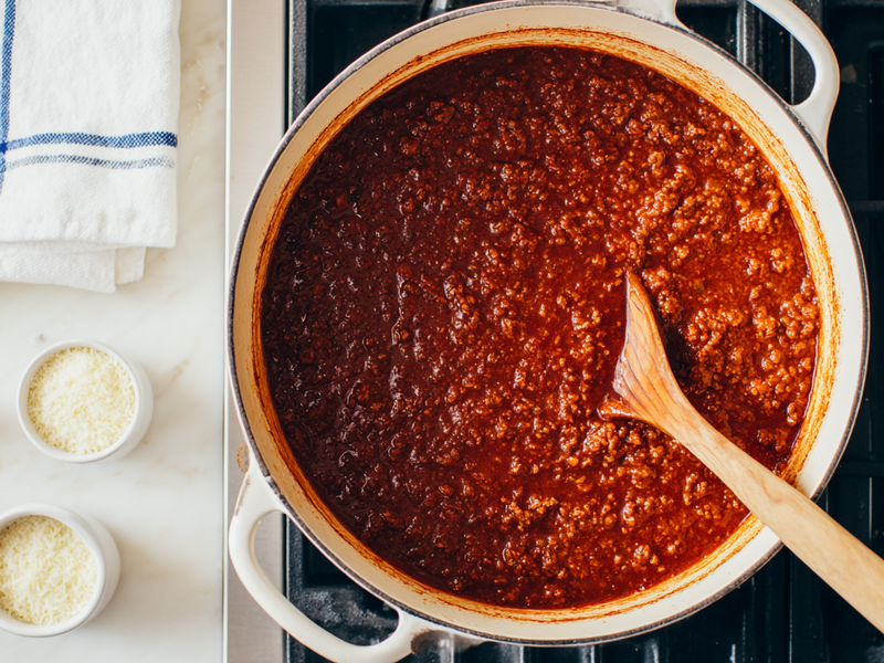 Bolognese sauce simmering and thickening in a Dutch oven on the stovetop