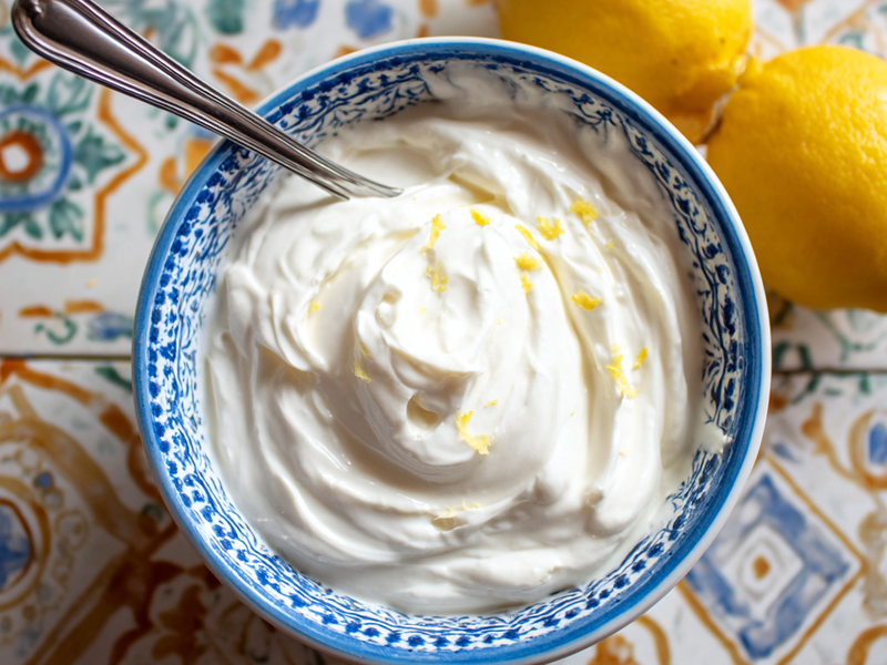 Greek yogurt and lemon juice mixed into a smooth sauce in a small bowl.