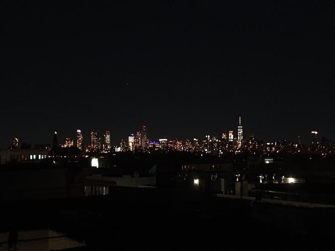 Manhattan seen from a Brooklyn rooftop by night