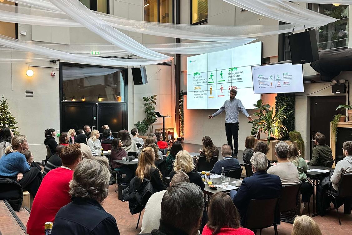 Bilde av en mann som prater for en gruppe mennesker.