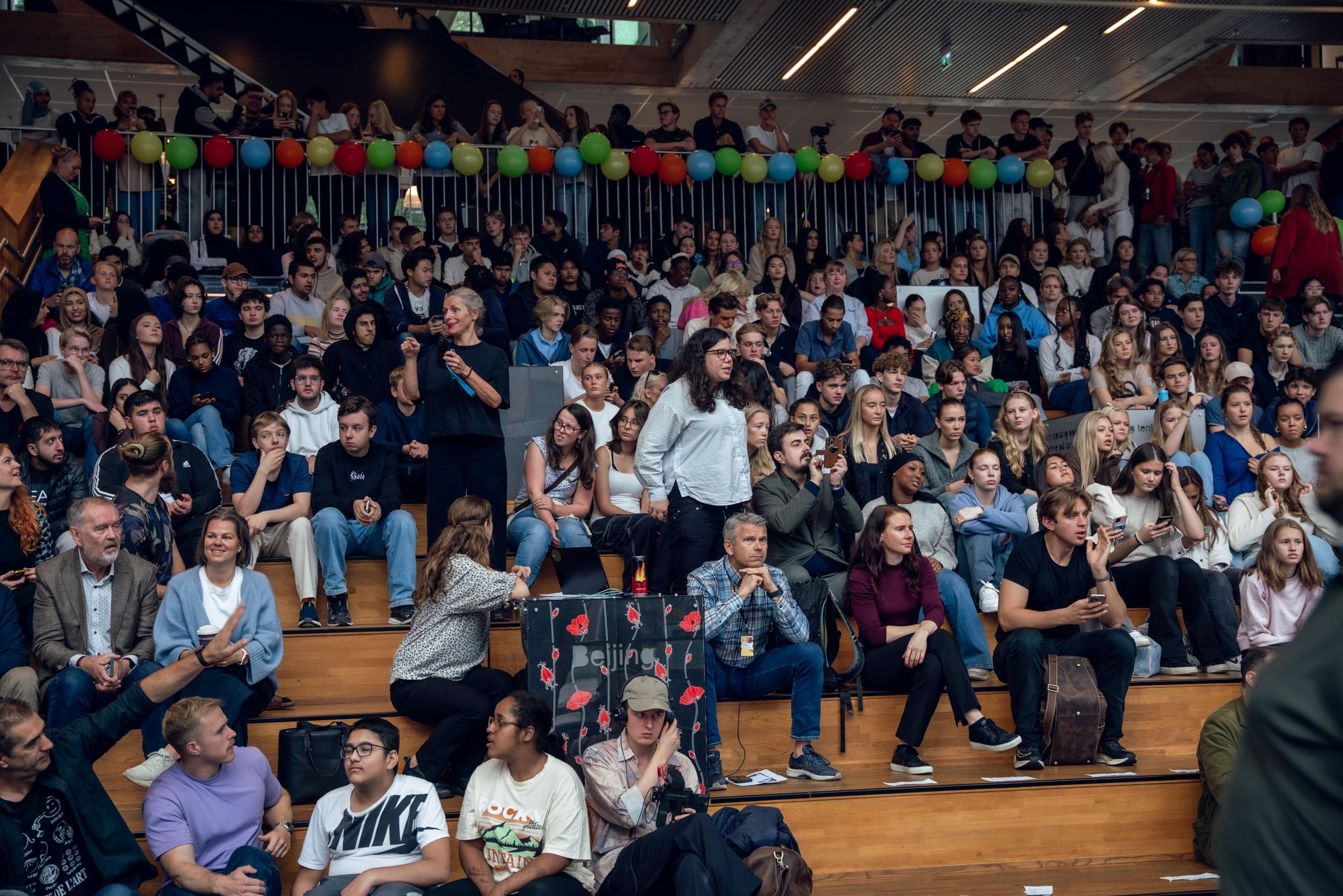 Bilde av en stor sal med mange mennesker.