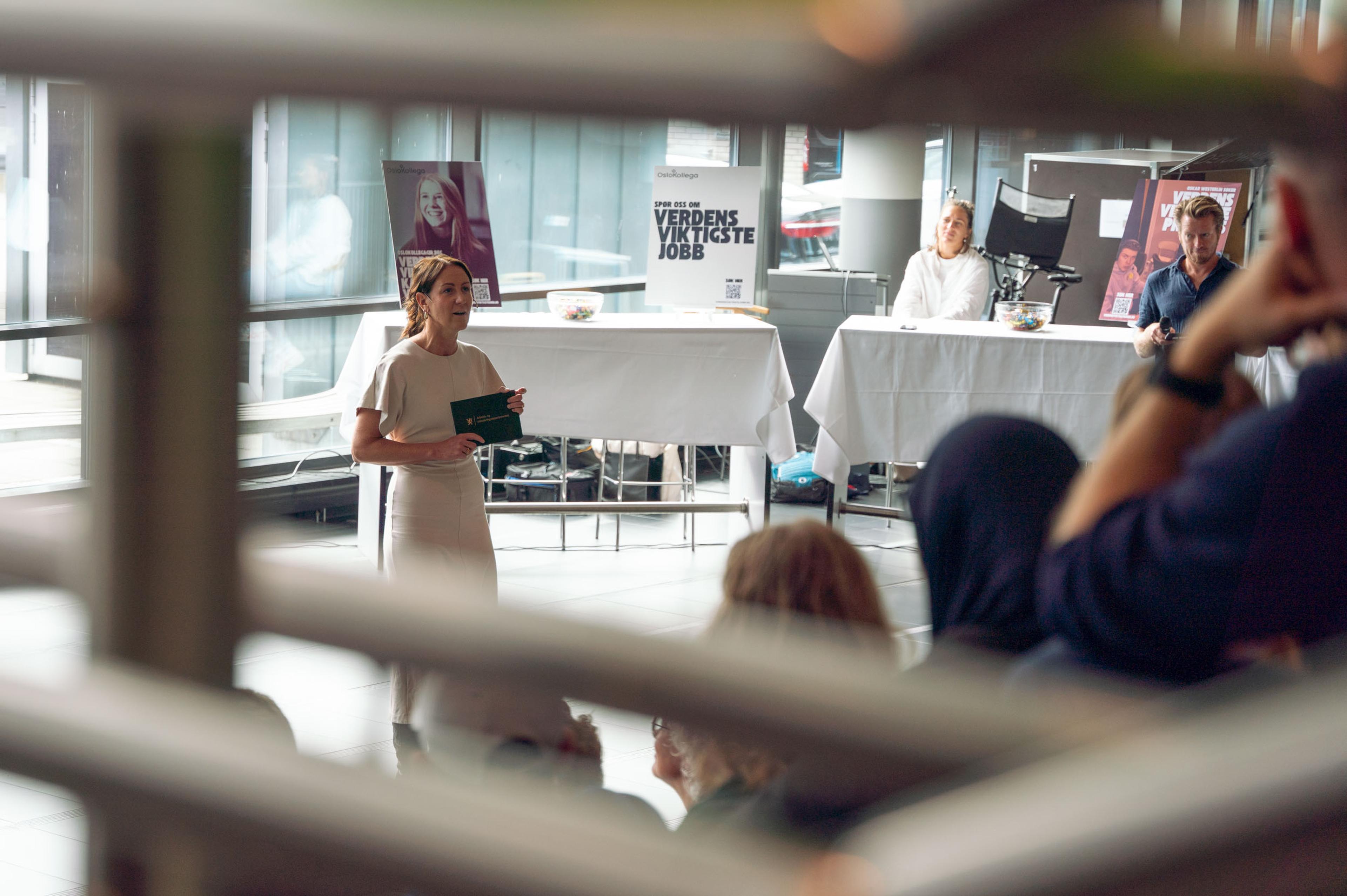 Bilde av Tonje Brenna som snakker foran en sal med mennesker.