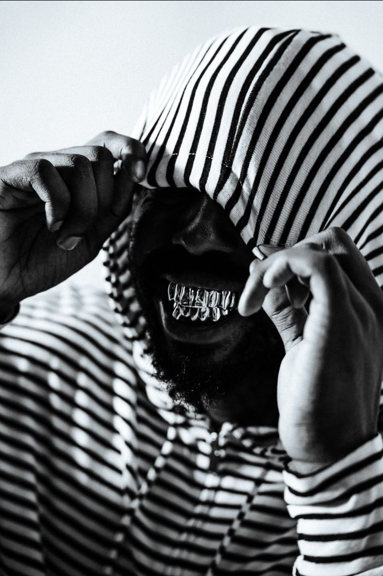 Grillz ajouré en métal précieux porté sur un sourire, photographie noir et blanc en lumière douce