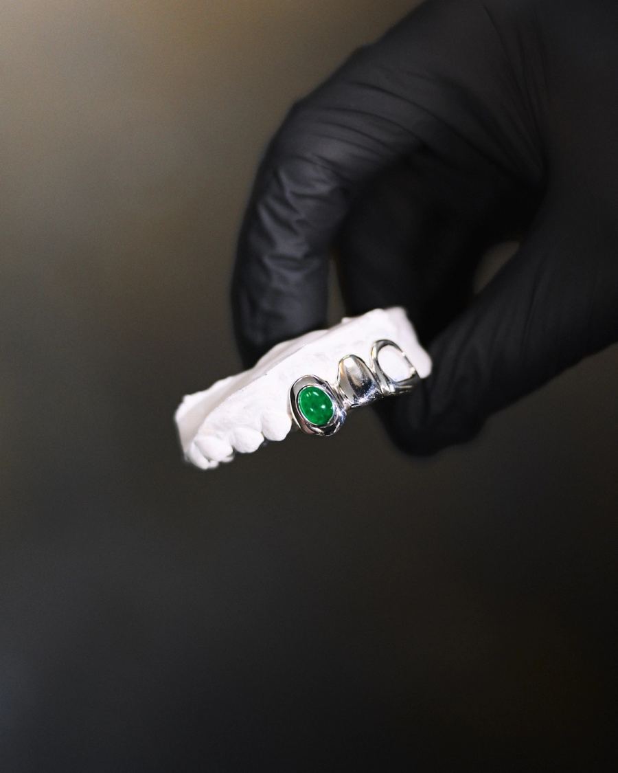 Grillz en or blanc serti d'une pierre verte