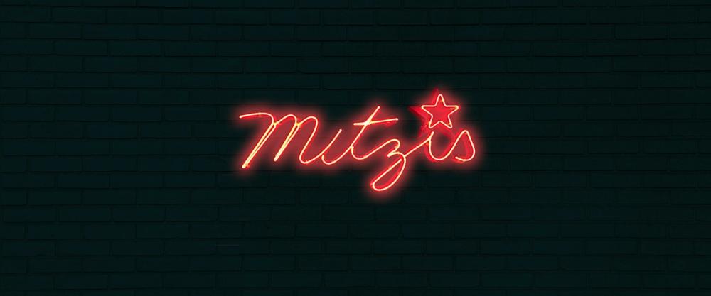 Photo of the neon sign for Mitzi's Bar.