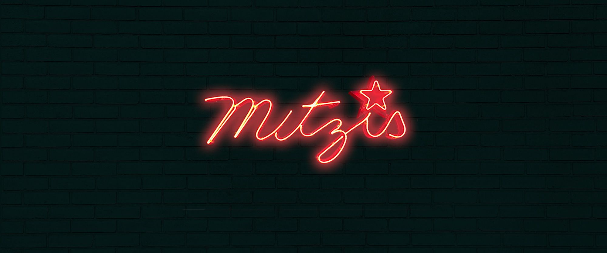 A photo of a neon sign reading "Mitzi's"
