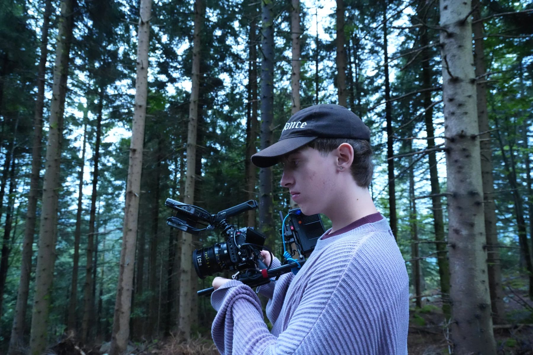 Cameraman met cinemacamera tussen de bomen