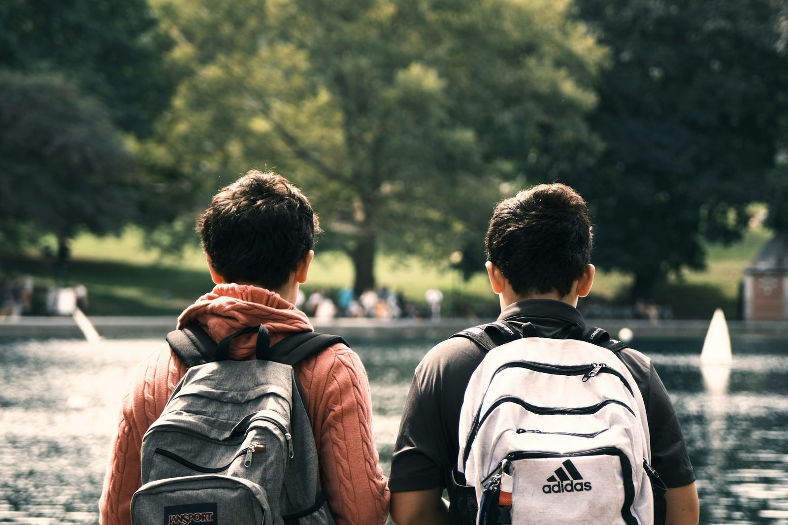 Deux élèves avec leur sac à dos, face à un parc