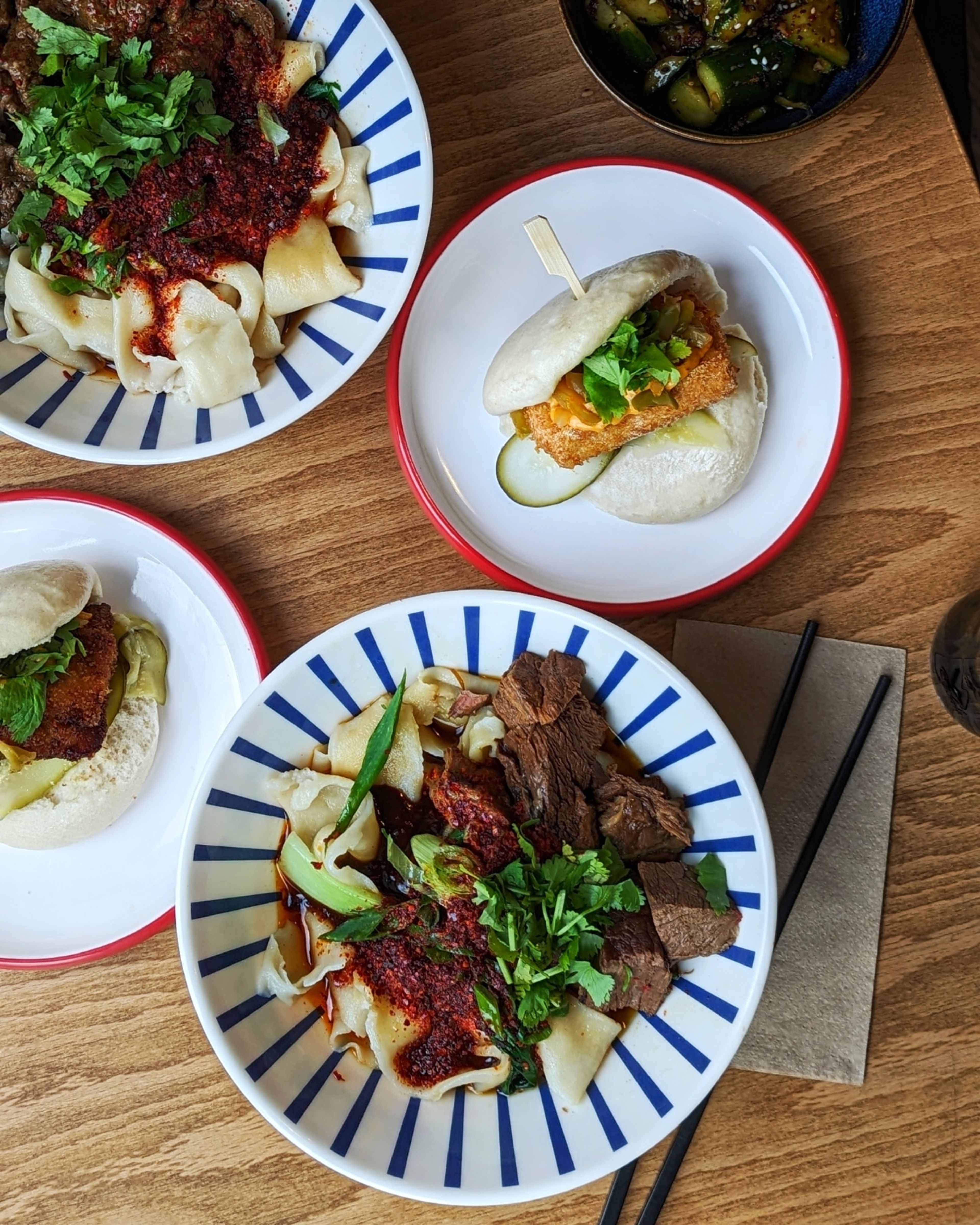 Breite Nudeln und Bao auf gedecktem Tisch bei Wen Cheng