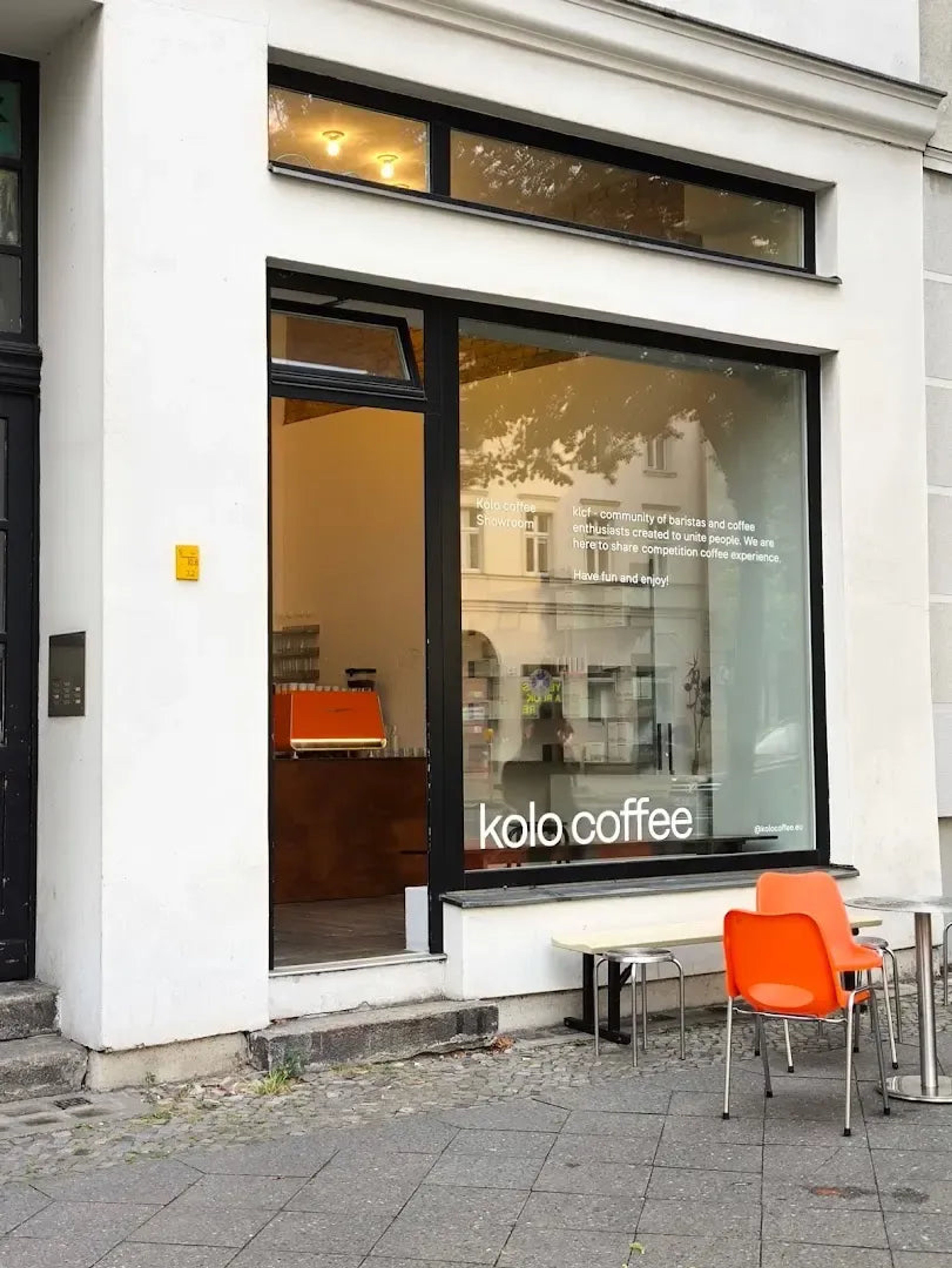 Kolo Coffee von außen: weiße Fassade und orange Stühle vor dem Laden in der Brunnenstraße