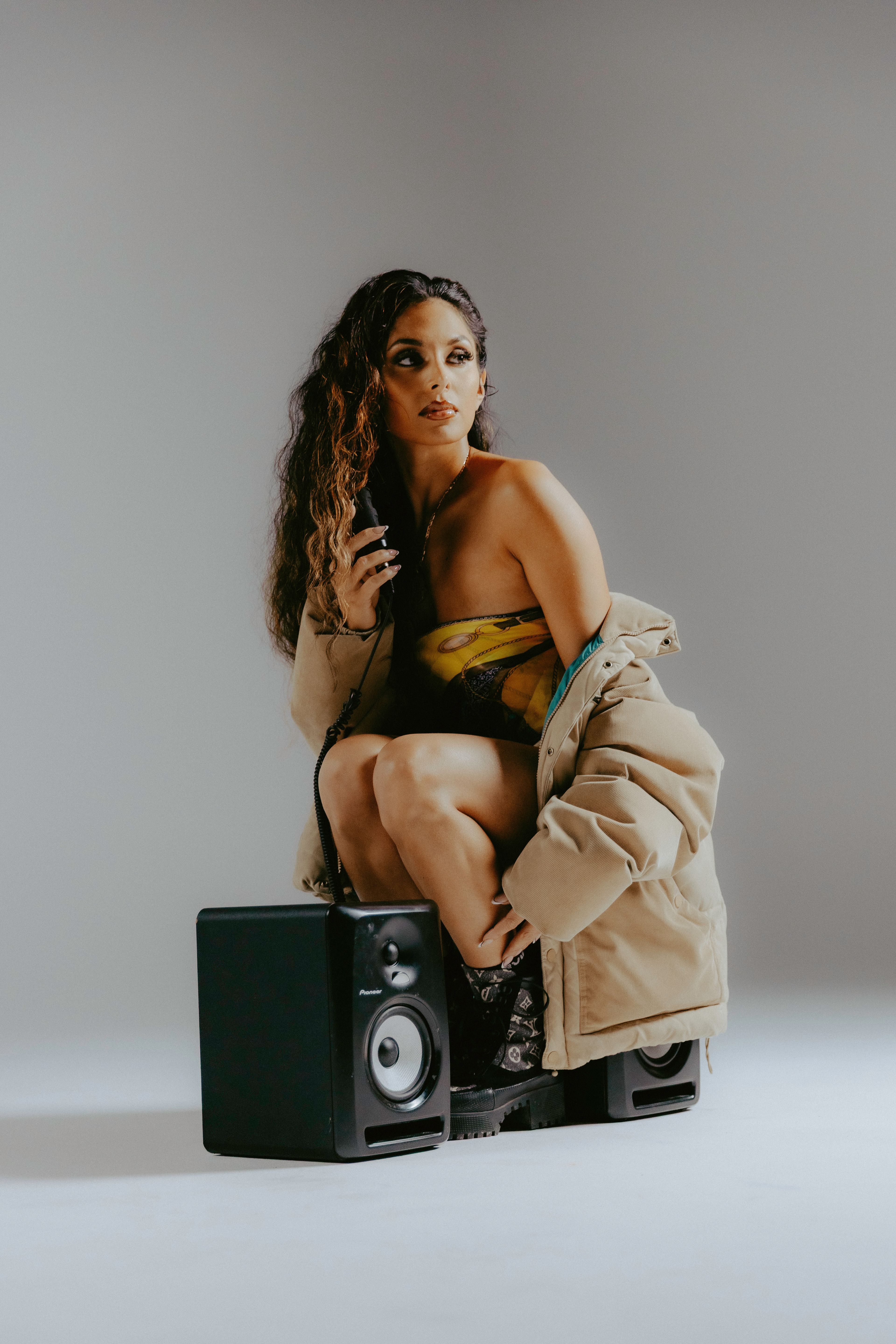 An editorial photo of Soraya sitting in between two speakers.