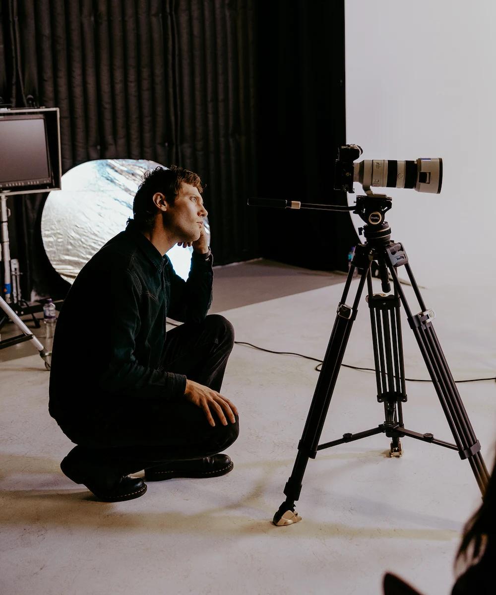 A photo of Oli looking through his camera during filming