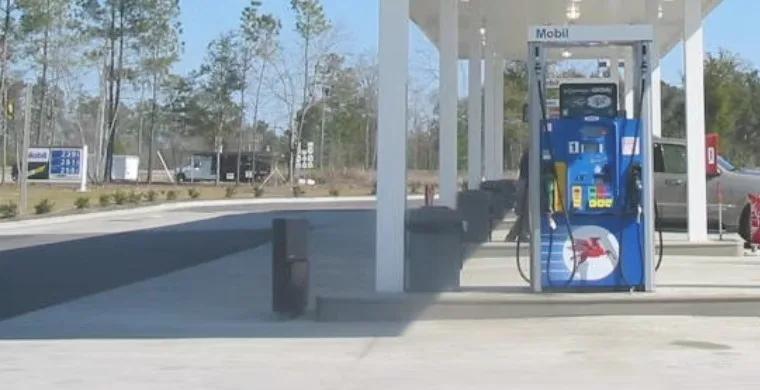 A fuel pump under a white fuel station canopy