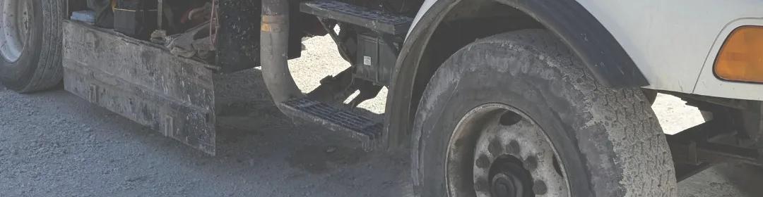 The front wheel and bumper of a well drilling truck