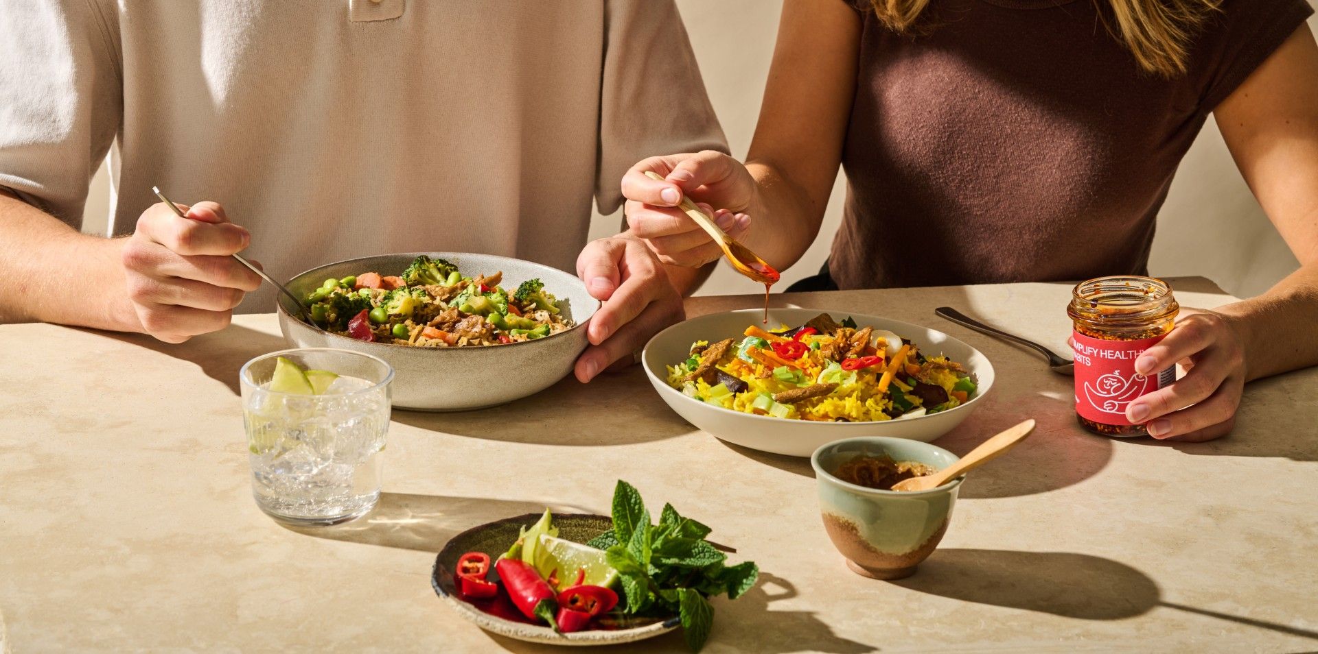 Twee personen eten hartige bowls.