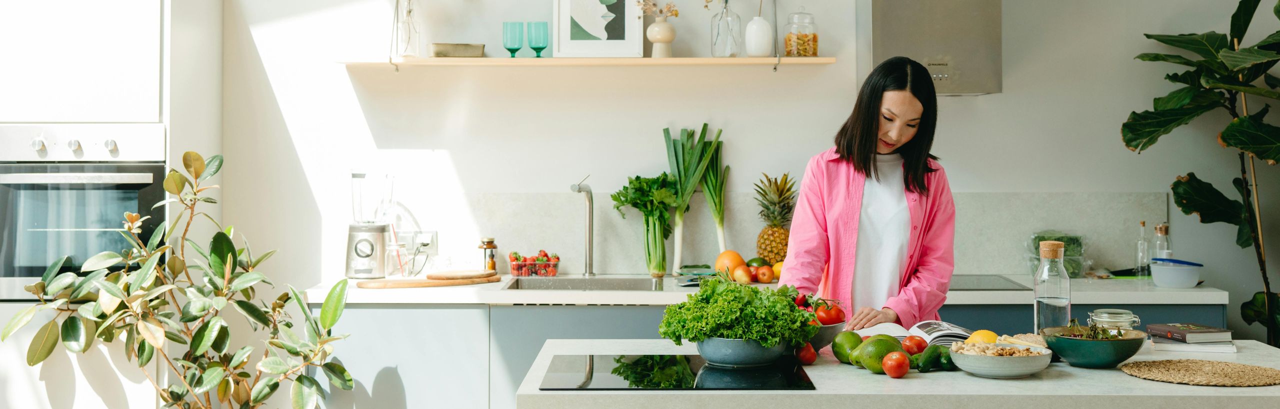 Een vrouw staat in de keuken en leest een kookboek