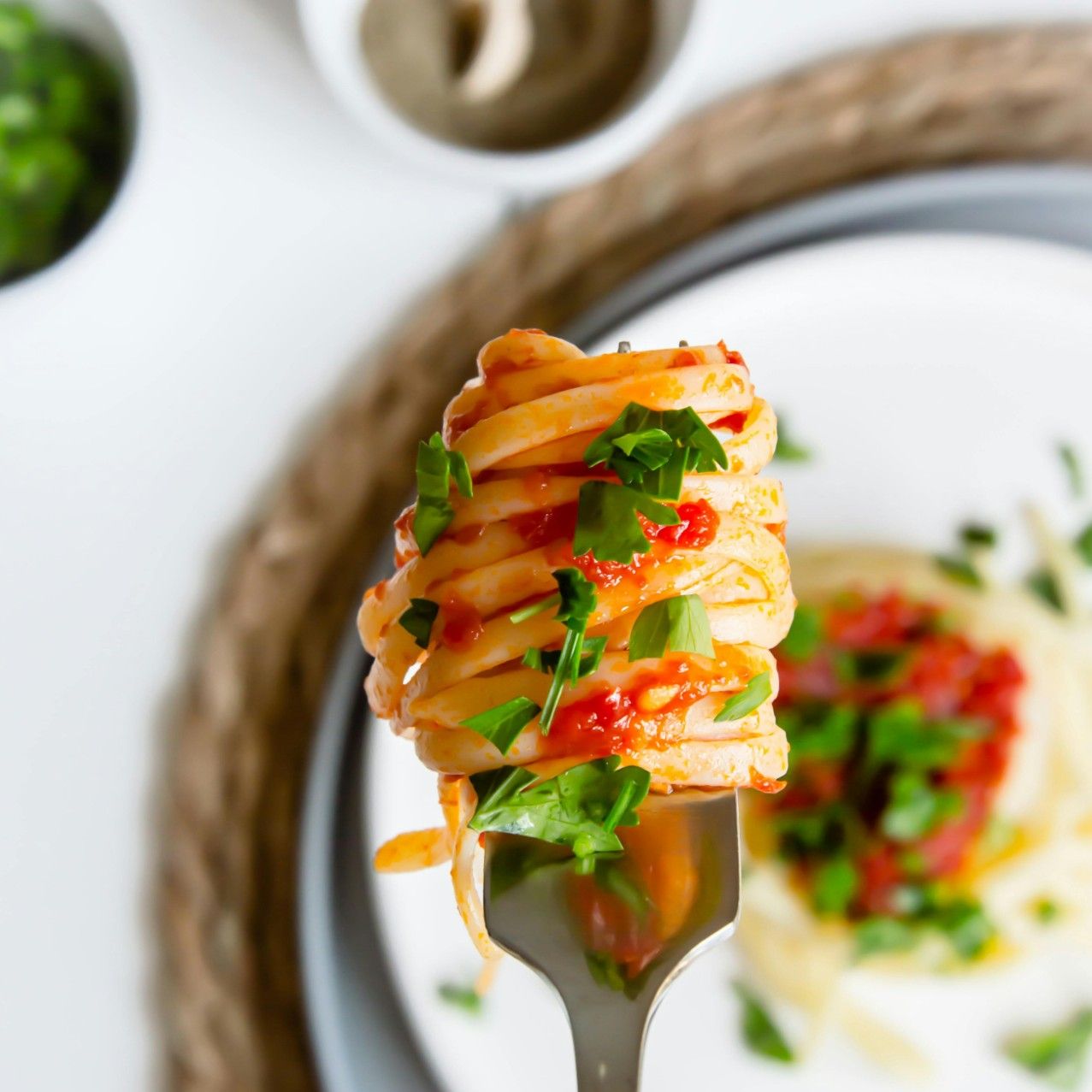 A fork of spaghetti with basil on top