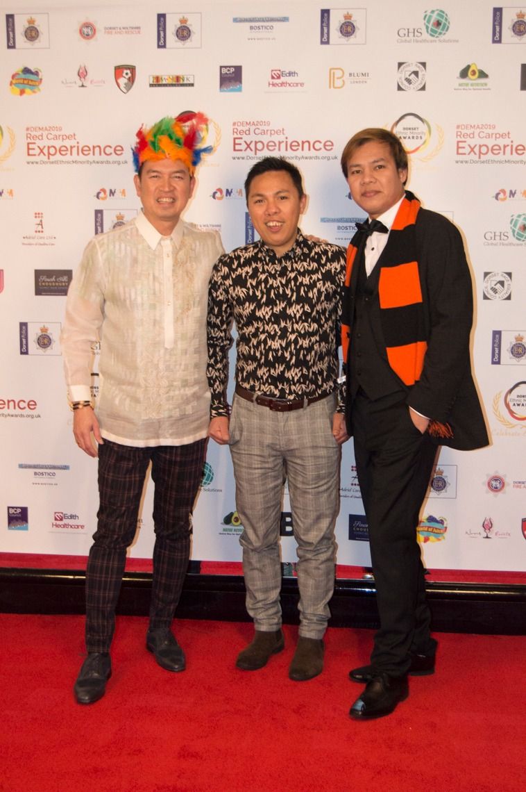 Three guests in colourful outfits on the red carpet