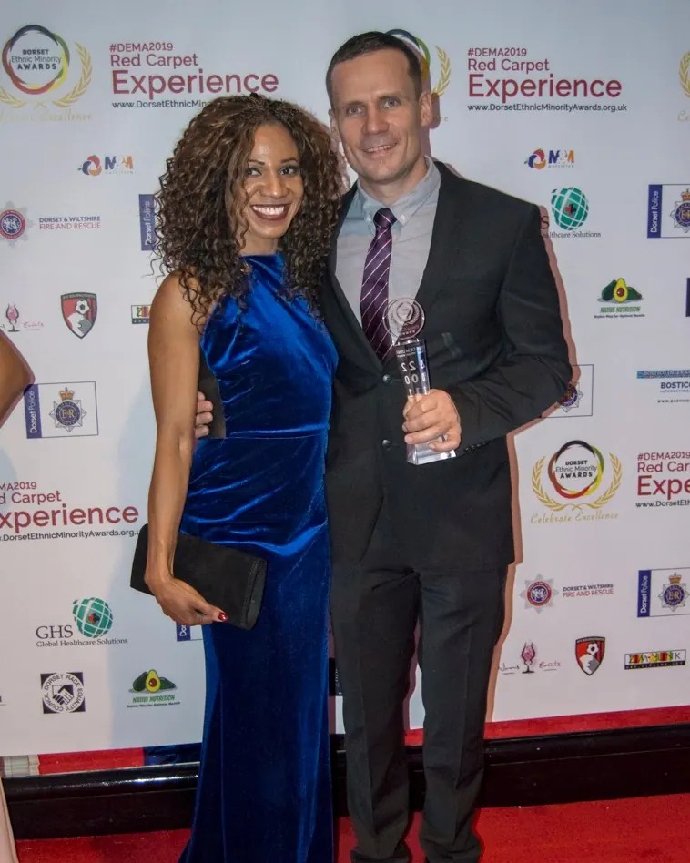 Two guests with a trophy on the red carpet