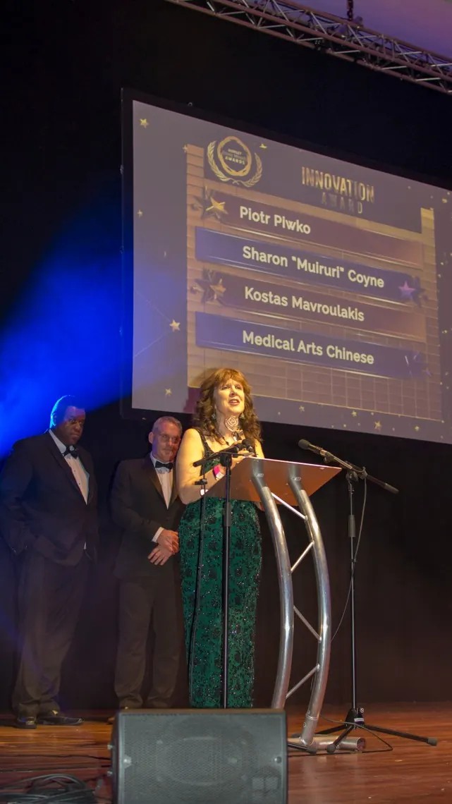The host addressing guests from the lectern on Awards night