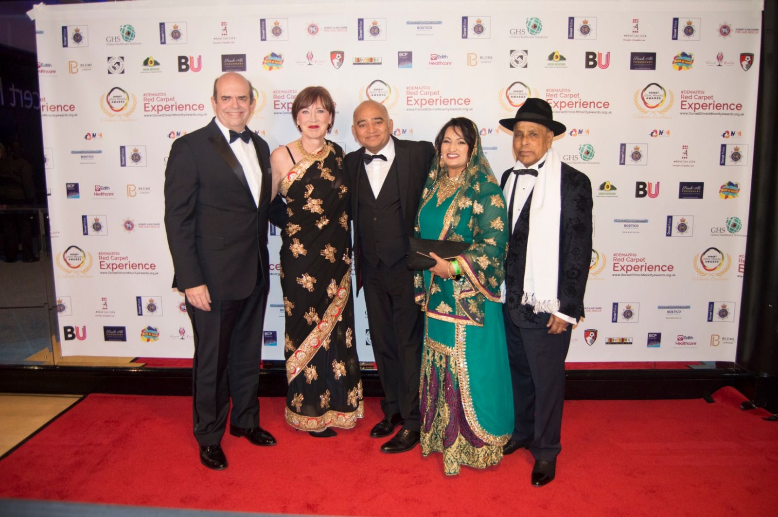 Guests in traditional dress and dinner suits on the red carpet