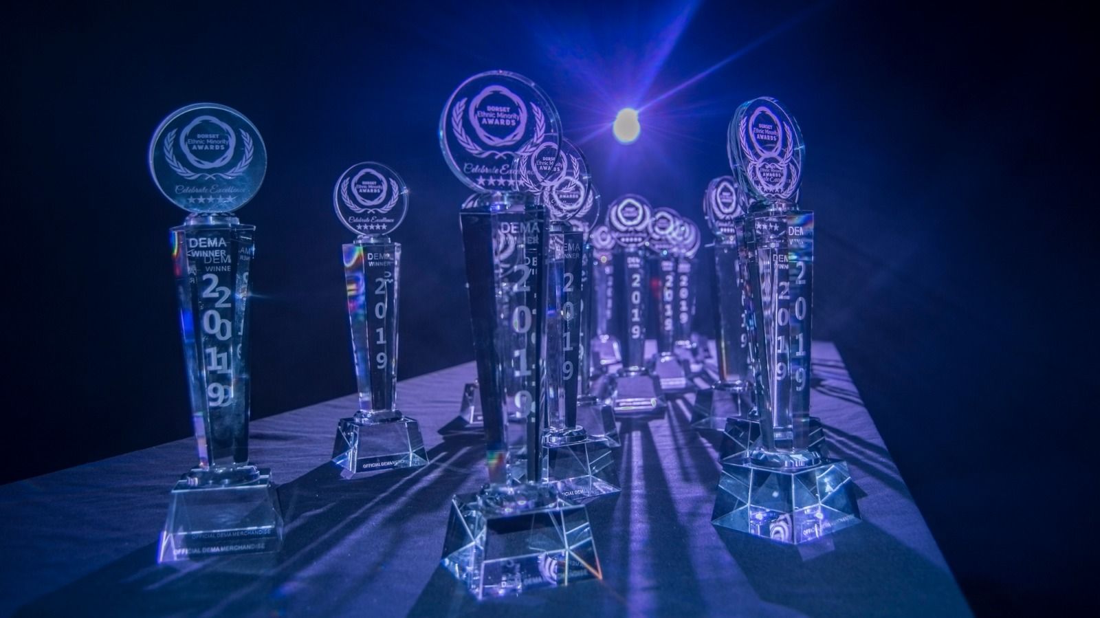 Crystal trophies on a table under stage lights