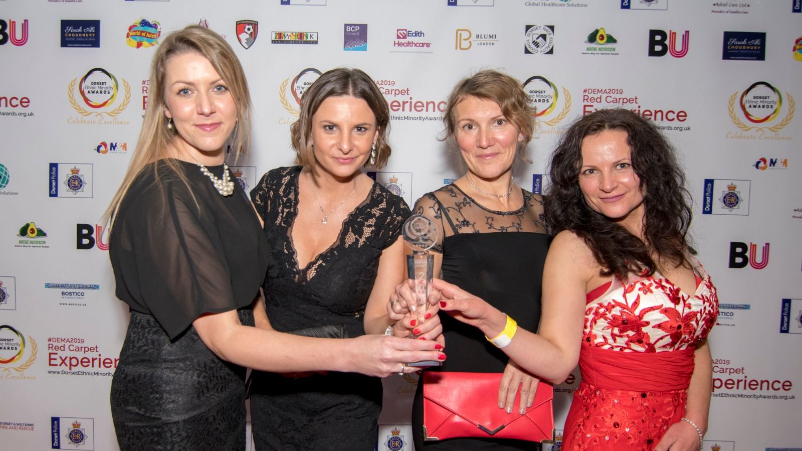 Four guests celebrating with a trophy