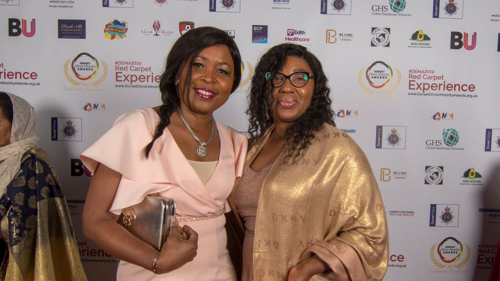 Two guests in pink and gold on the red carpet