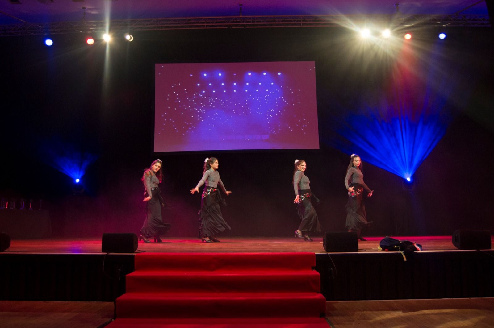 Dancers performing on the stage under spotlights