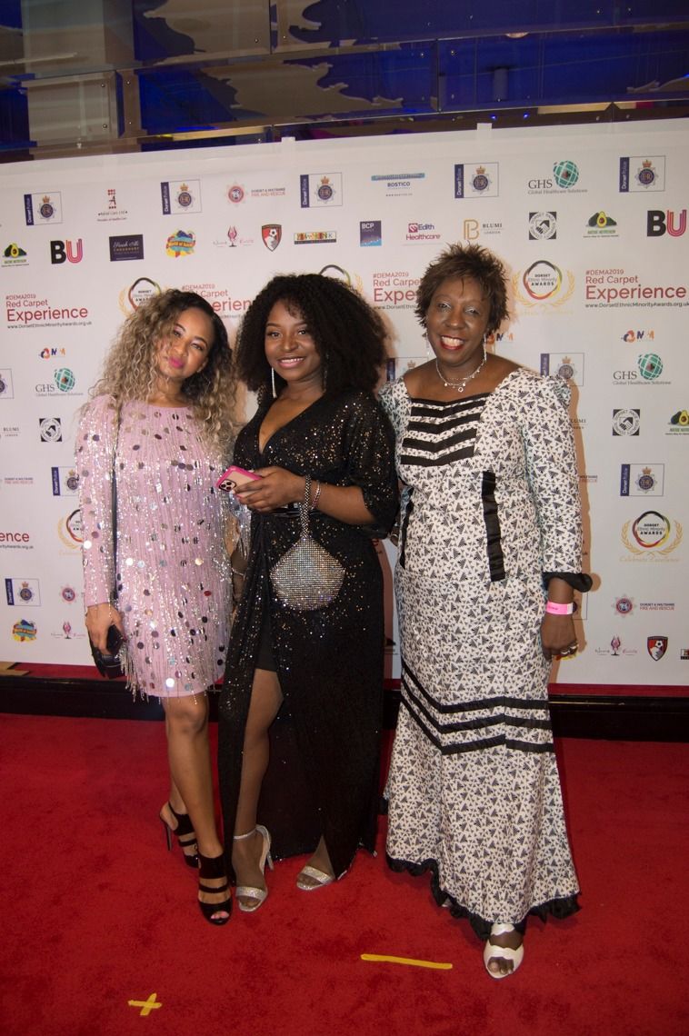 Three guests in patterned dresses on the red carpet