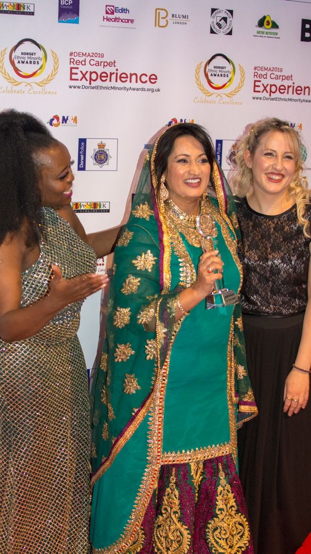 Three guests, one in an embroidered sari, on the red carpet