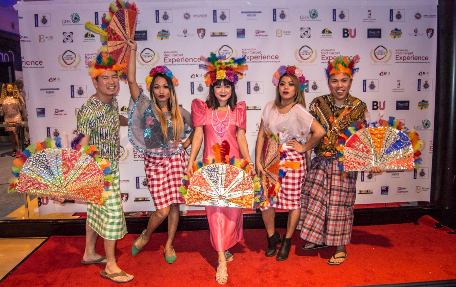 Dancers with feathered fans posing on the red carpet