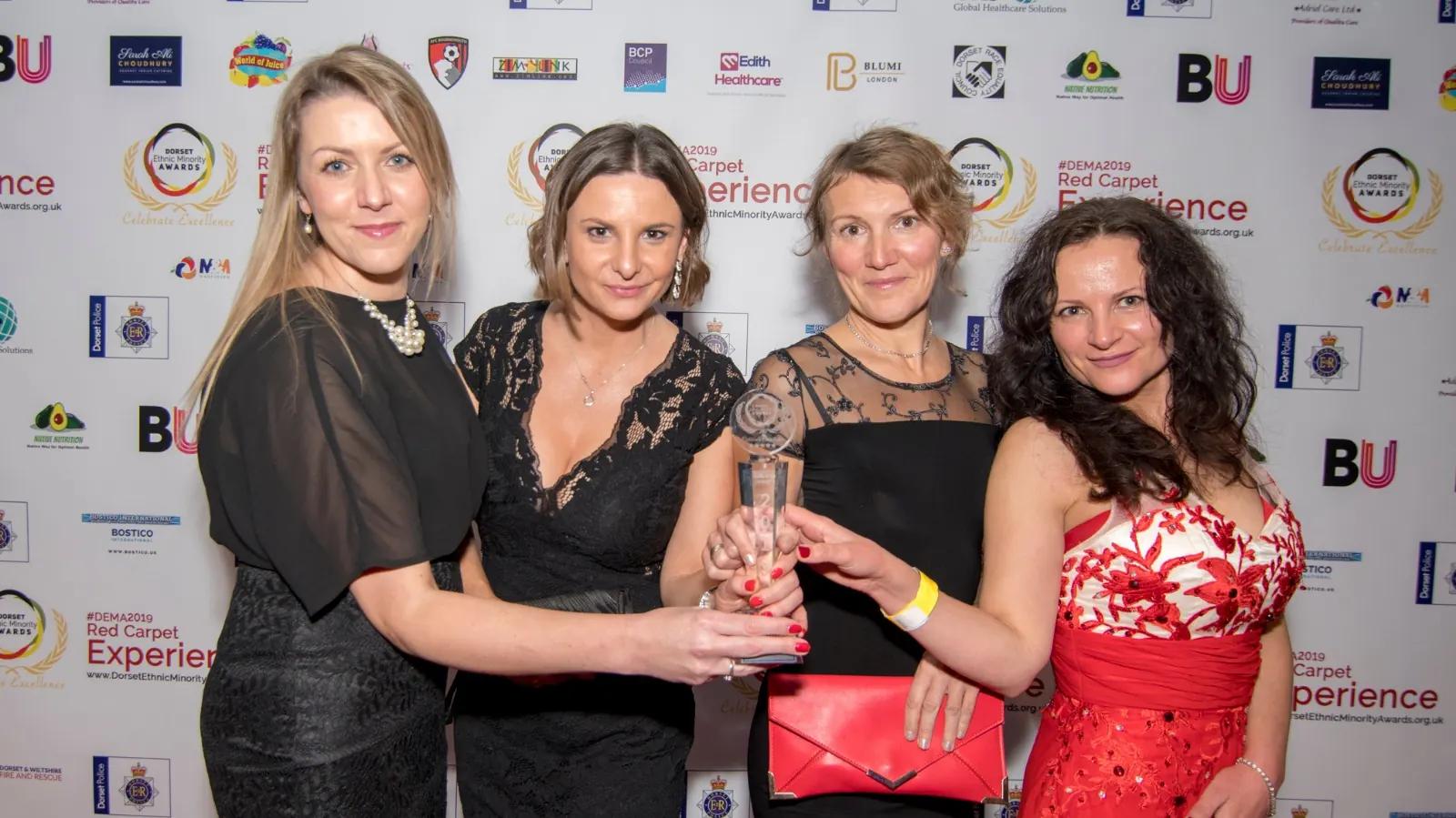 Four guests celebrating with a trophy