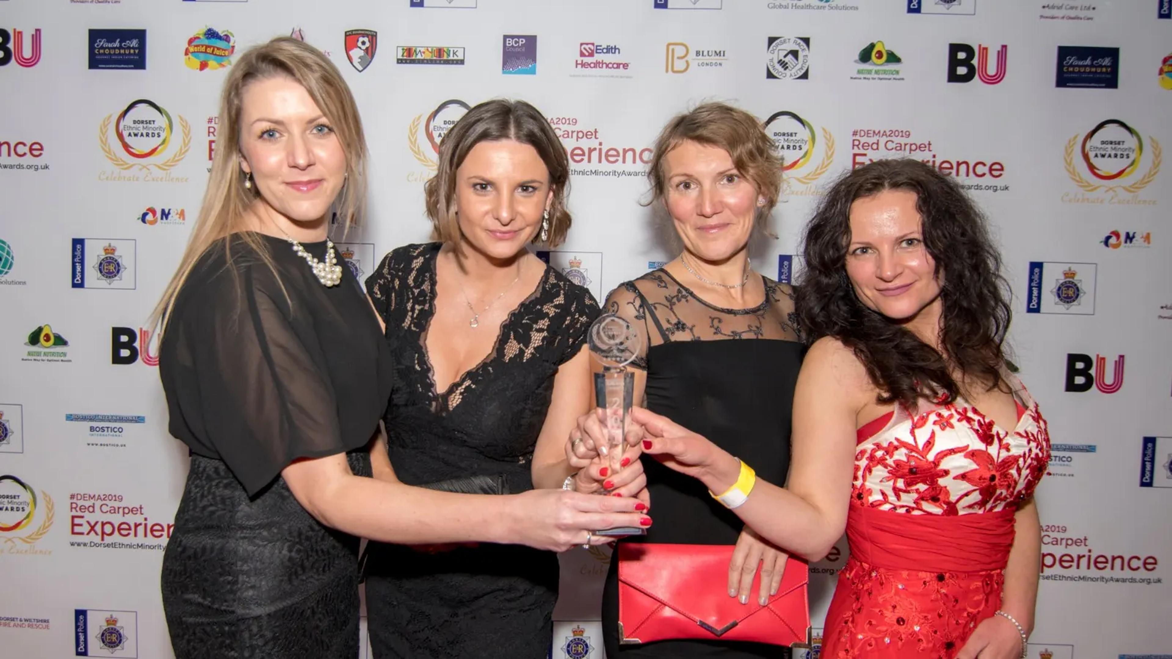 Four guests celebrating with a trophy