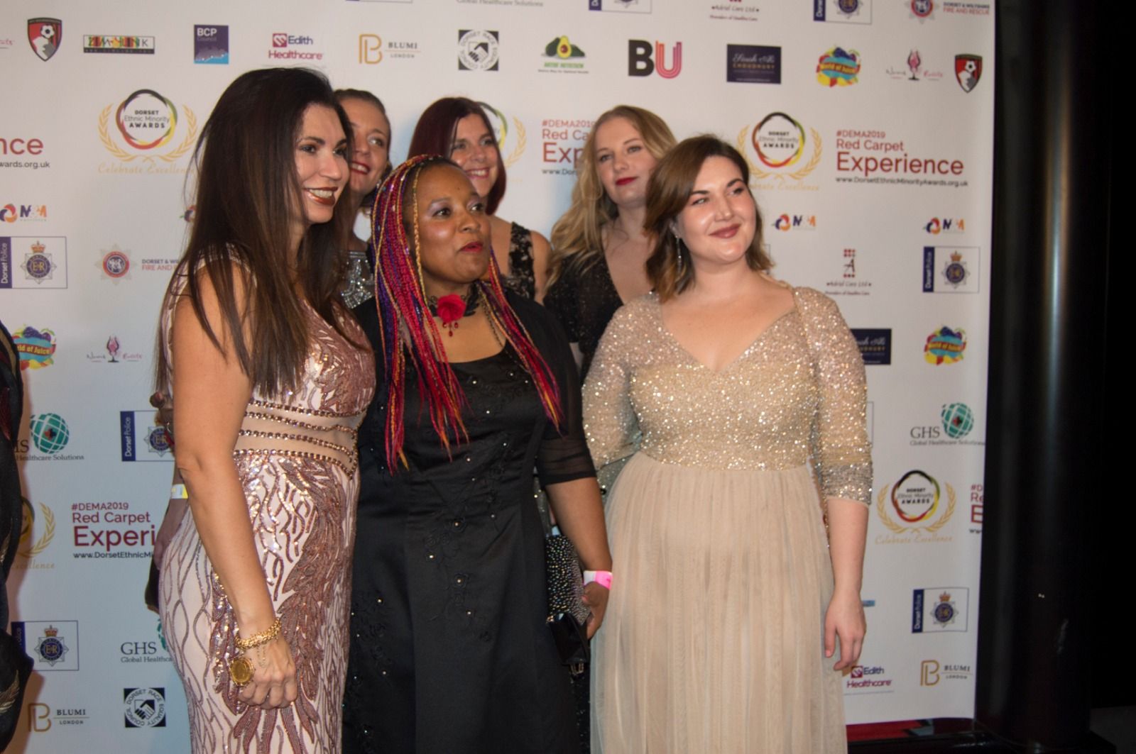 A group of guests in sparkling evening wear on the red carpet