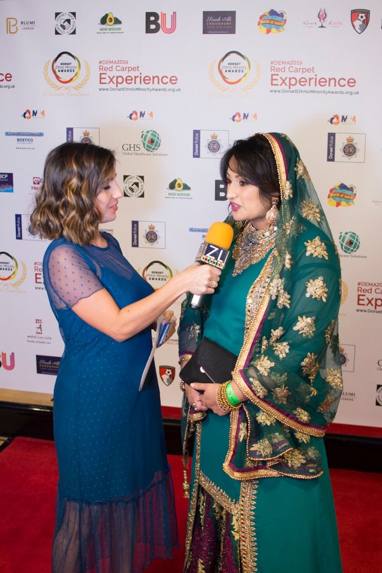 A guest in an embroidered green dupatta being interviewed on the red carpet