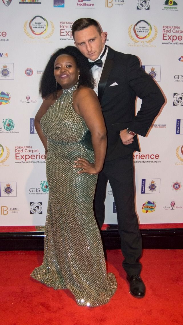 A couple in a sequinned gown and dinner suit on the red carpet