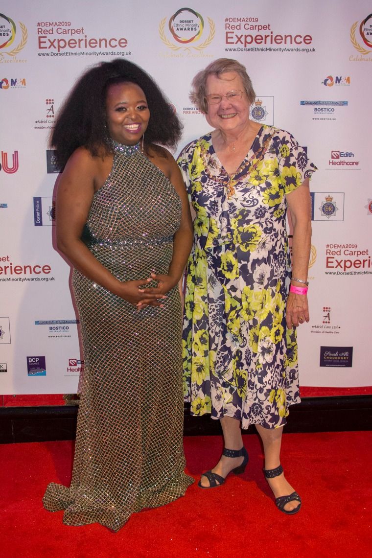 Two guests in a sequinned gown and floral dress on the red carpet