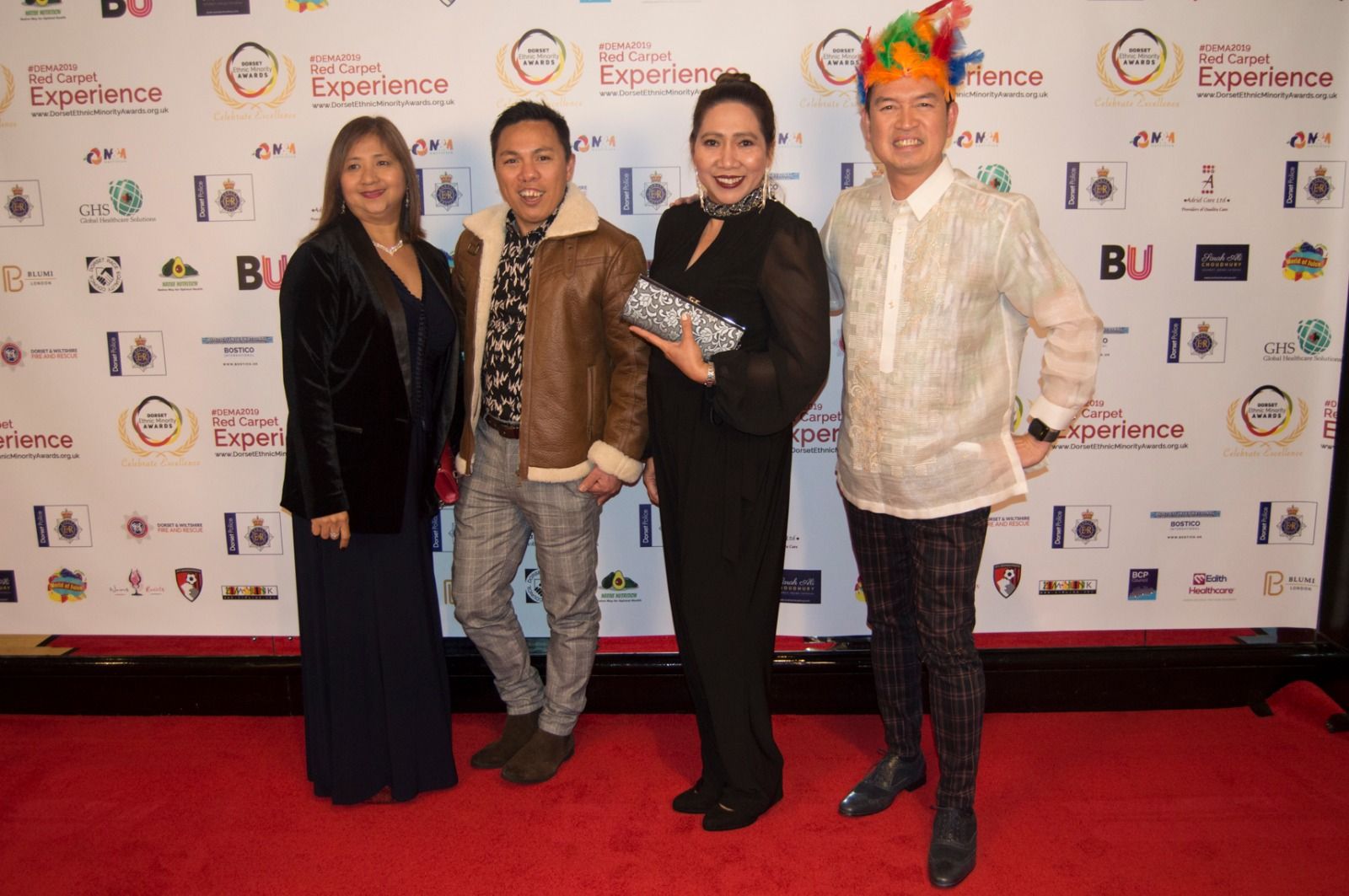 Four guests posing together on the red carpet