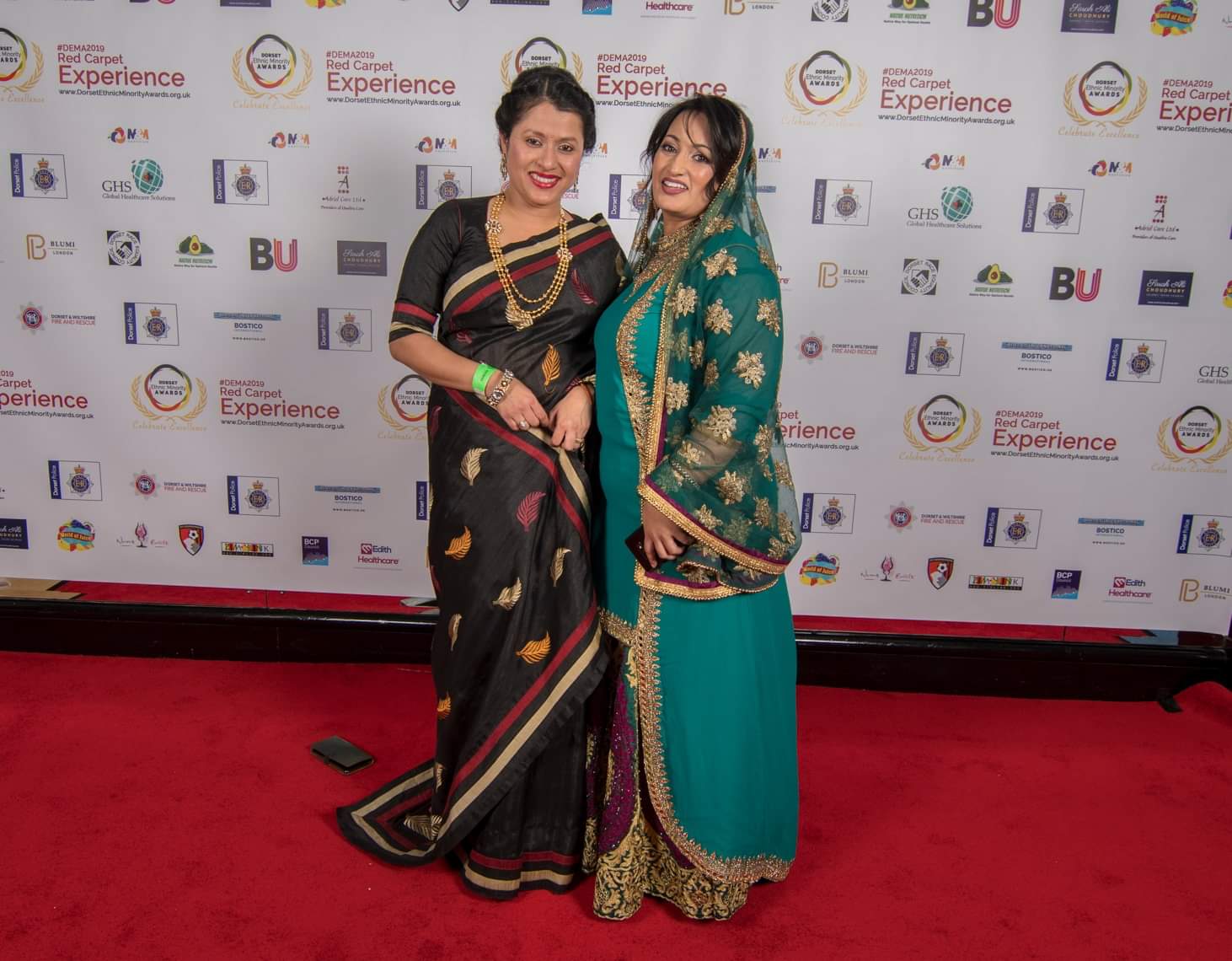 Two guests in traditional saris on the red carpet