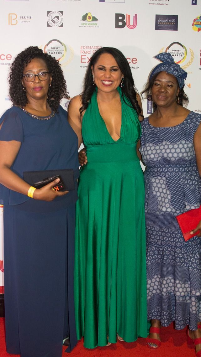 Three guests in green and blue gowns on the red carpet